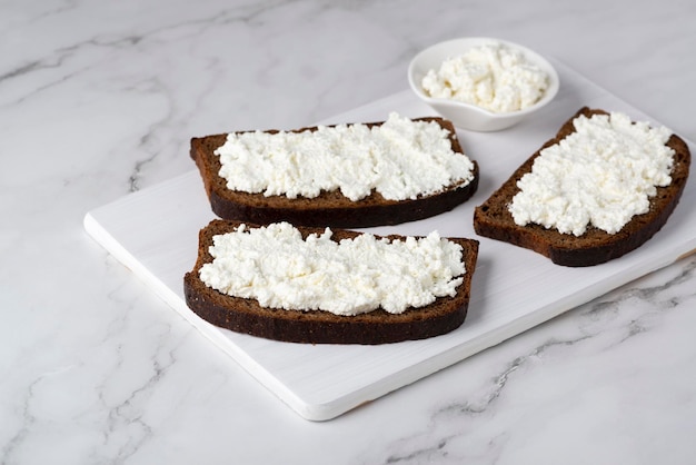 Pan de centeno con requesón en una mesa blanca