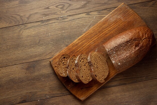 pan de centeno en rodajas recién horneado sobre una tabla para cortar madera