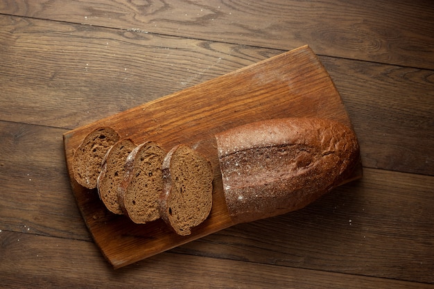 pan de centeno en rodajas recién horneado sobre una tabla para cortar madera