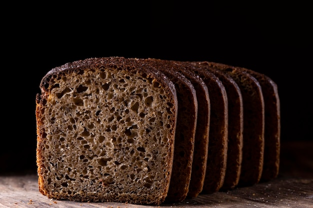 Pan de centeno en rodajas sobre un fondo negro.