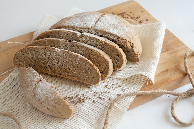 Pan de centeno en rodajas sobre tabla de cortar de madera