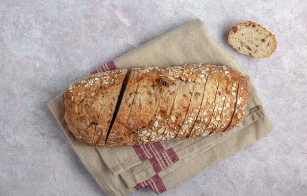 Pan de centeno con semillas, pasas y muesli Concepto de comida saludable Pan italiano la pagnotta sobre fondo beige claro Vista superior