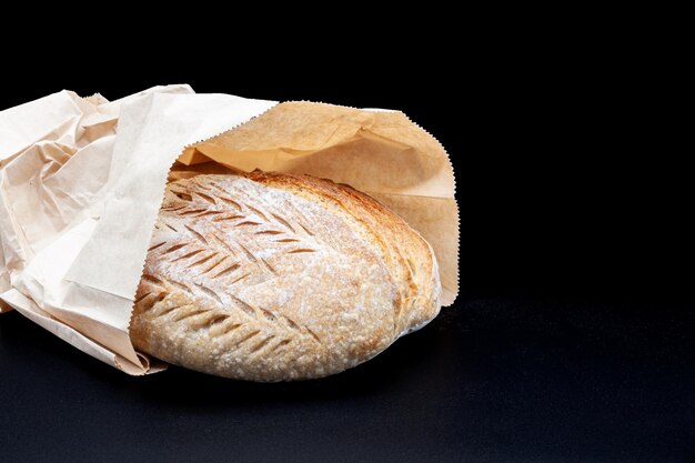 Pan de centeno de Vermont recién horneado con corteza crujiente y textura porosa en harina y bolsa de bemag