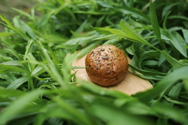 Pan de cereal negro sobre una tabla de madera entre verduras jugosas