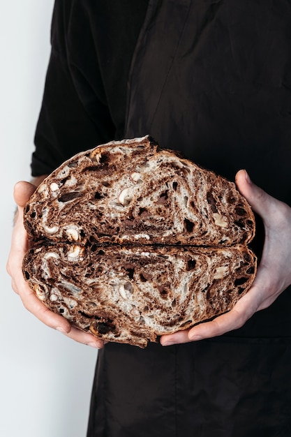 Pan de chocolate vegano en manos de panadero. Sin gluten y sin productos animales.