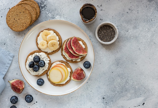 Pan crujiente de avena con diferentes frutas y bayas en un plato blanco tostadas de galletas de desayuno saludable