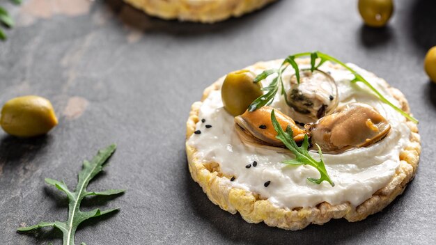 Pan crujiente bocadillo saludable Mejillones tostadas de bruschetta con queso suave y rúcula Vista superior de formato de banner largo