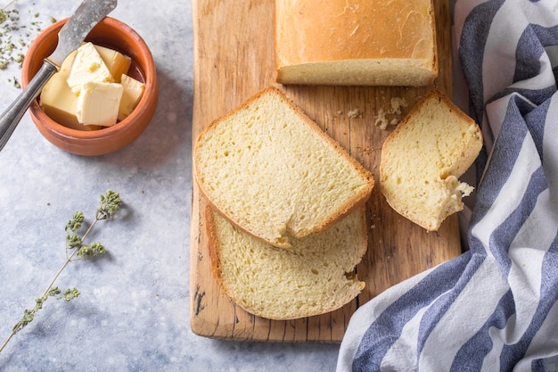 Pan crujiente casero y rebanadas con aceite de oliva, mantequilla y aceitunas verdes, vista superior. Horneando