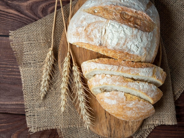 Pan crujiente fresco y delicioso se encuentra sobre un fondo de madera Rebanadas de pan servilleta de lino Concepto de panadería para hornear Vista superior plana