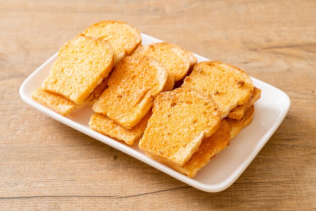 Pan crujiente horneado con mantequilla y azúcar en un plato