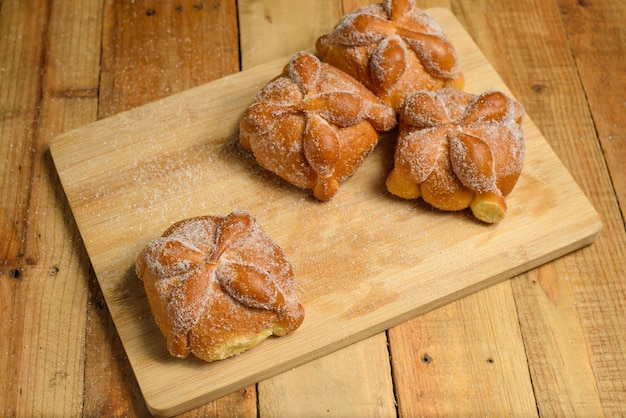 Pan de muertos auf einem Holztisch. Typisch mexikanisches Dessert zum Tag der Toten.