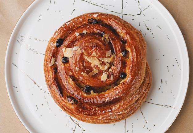 Foto pan dulce con pasas y almendras en un plato blanco