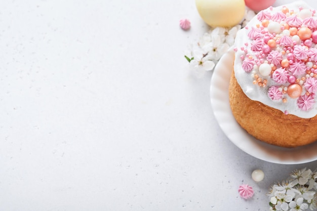 Pan dulce tradicional de Pascua o pasteles con glaseado blanco y decoración de azúcar huevos de colores y rama de cerezo sobre mesa blanca Varios pasteles de Pascua de primavera Feliz día de Pascua Enfoque selectivo