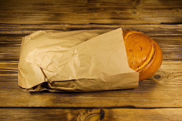 Pan envasado en papel sobre mesa de madera