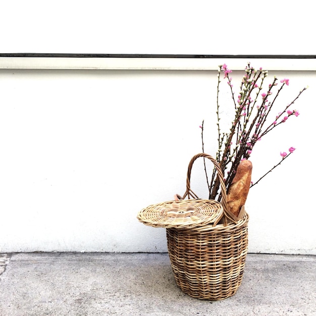 Foto pan y flores en una canasta de mimbre contra la pared