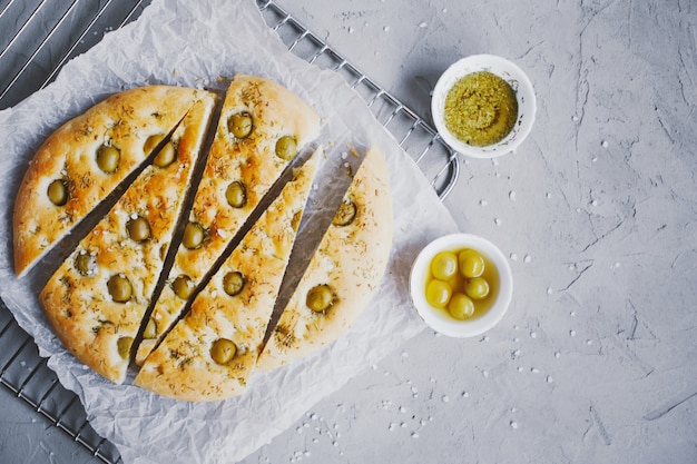 Pan focaccia tradicional italiana con aceitunas, romero, sal y aceite de oliva