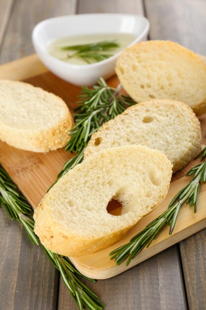 Foto pan fresco con aceite de oliva y romero en mesa de madera