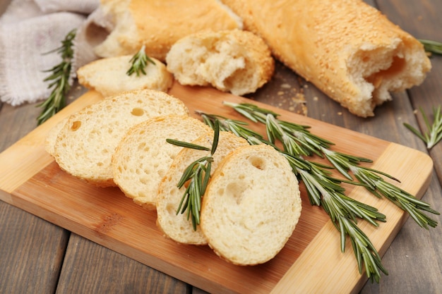 Pan fresco con aceite de oliva y romero en mesa de madera