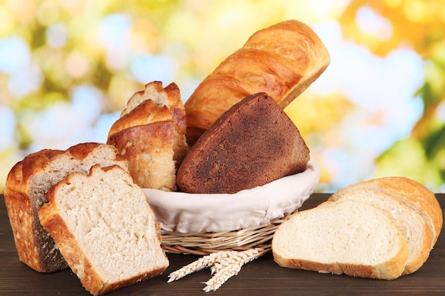 Pan fresco en cesta sobre mesa de madera sobre fondo natural