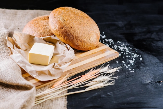 Pan fresco dulce con ingredientes sobre fondo de madera negra