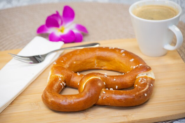 El pan fresco y fragante con una hermosa flor de café es un buen desayuno para el cuerpo sobre la mesa.