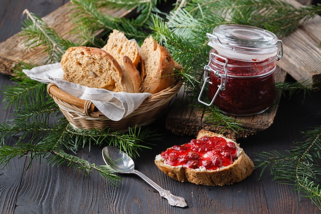 Pan fresco con mermelada de arándanos y frutas en una mesa rústica