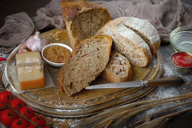 Pan fresco sobre un fondo antiguo con accesorios de cocina en la mesa.