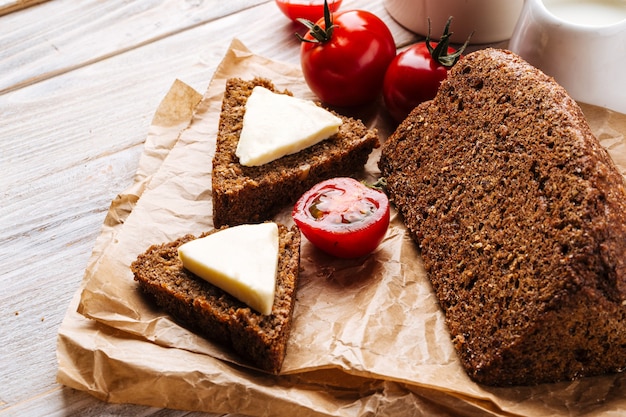 Pan de grano de dieta sin harina con queso y café en la mesa de madera