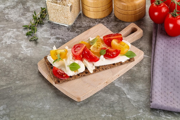 Foto pan de grano con tomate y queso crema