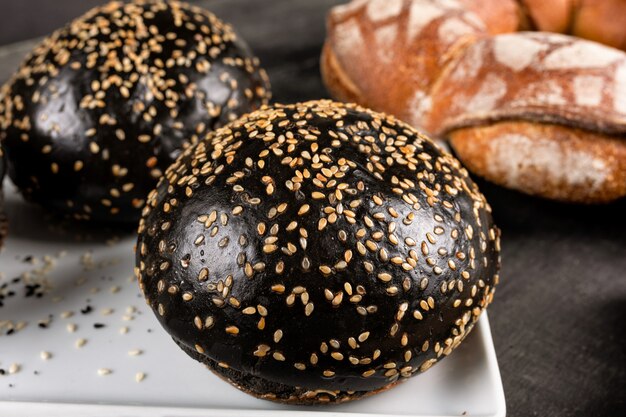 Pan de hamburguesa negro oscuro y fresco de cerca