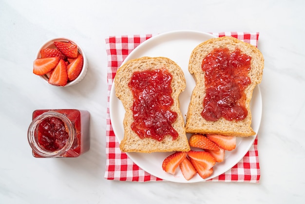 Foto pan integral casero con mermelada de fresa y fresa fresca