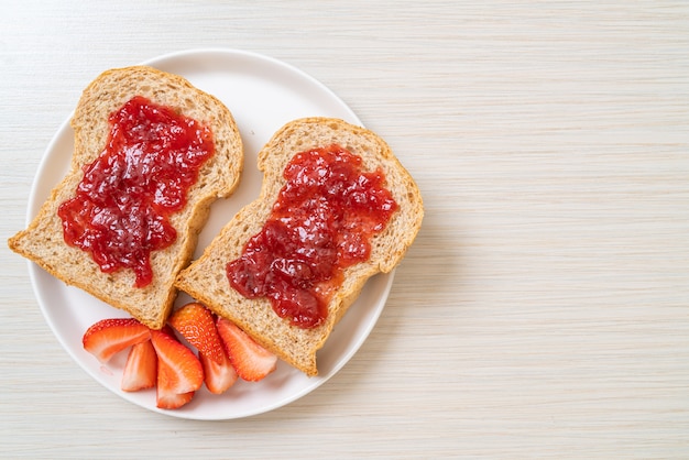 Foto pan integral con mermelada de fresa y fresa fresca