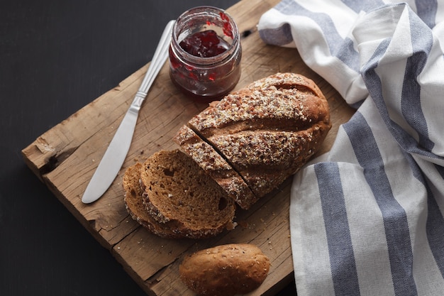 Pan integral oscuro de grano entero y mermelada recién horneado en rústico