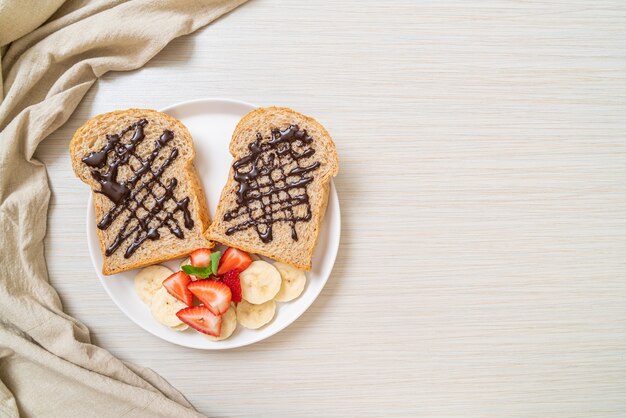 pan integral tostado con plátano fresco, fresa y chocolate para el desayuno