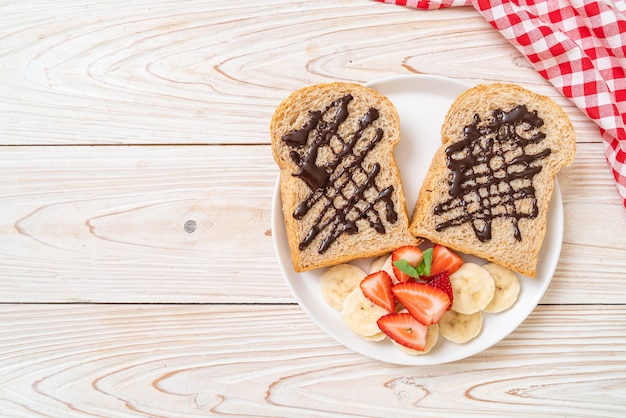 pan integral tostado con plátano fresco, fresa y chocolate para el desayuno