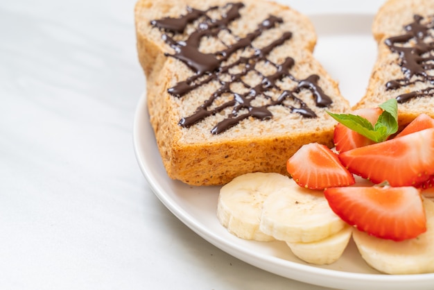 pan integral tostado con plátano fresco, fresa y chocolate para el desayuno