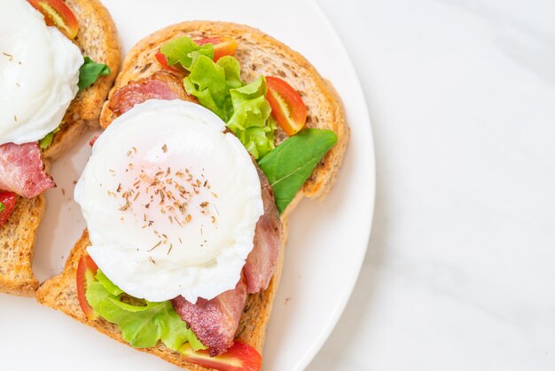 pan integral tostado con vegetales, tocino y huevo o huevo benedicto para el desayuno