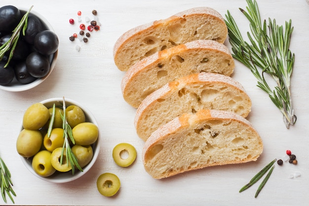 Pan italiano ciabatta con aceitunas y romero en una tabla de cortar