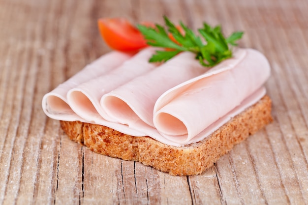 Pan con jamón rebanado, tomate fresco y perejil.