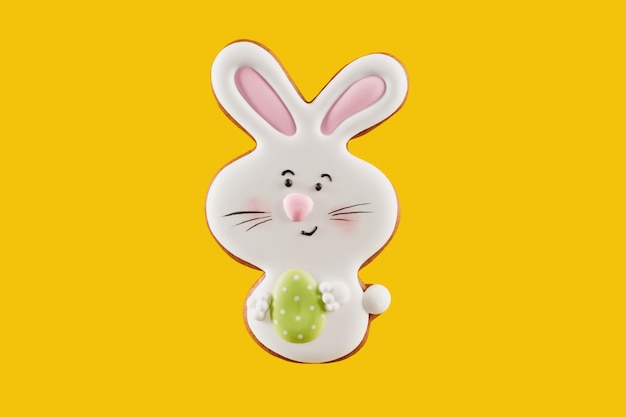 Pan de jengibre en forma de conejito de pascua que sostiene un huevo pequeño