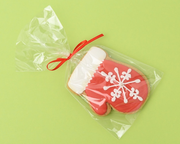 Pan de jengibre horneado en forma de manopla y cubierto con glaseado rojo, clásico postre navideño