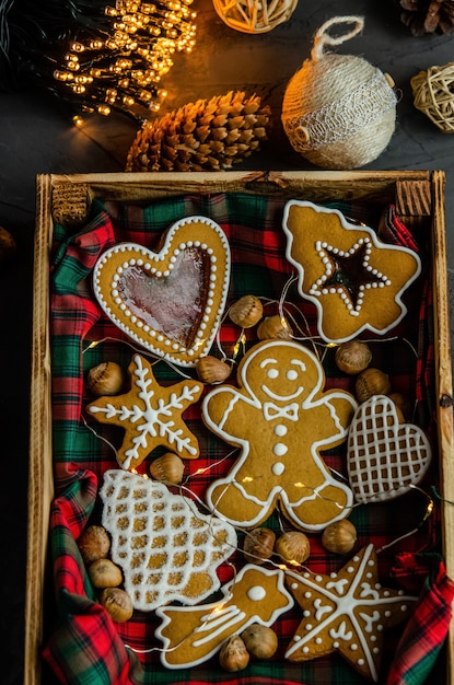 Foto pan de jengibre de navidad con azúcar glas blanco pintado sobre un fondo oscuro.