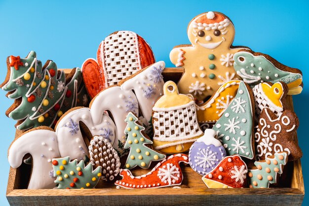 Pan de jengibre de Navidad en una caja de madera sobre fondo azul.