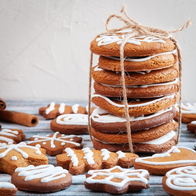 Pan de jengibre de Navidad decorado con glaseado blanco sobre fondo gris de madera Primer plano