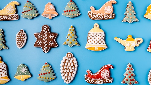 Pan de jengibre de Navidad sobre un fondo azul. Copo de nieve, abeto, estrella, cono, estrella, forma de campana.