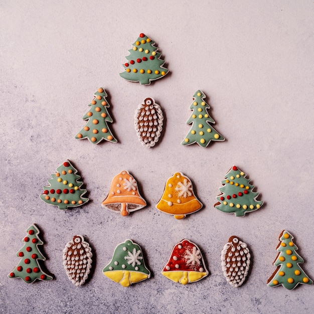 Pan de jengibre de Navidad sobre fondo gris. Abeto, copo de nieve, abeto, manopla, conos, campana.