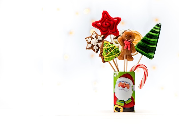 Pan de jengibre navideño y dulces de caramelo en palitos. Fondo festivo de Navidad con bokeh, espacio de copia para texto