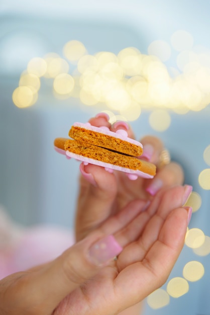 Pan de jengibre roto sostenido por manos femeninas