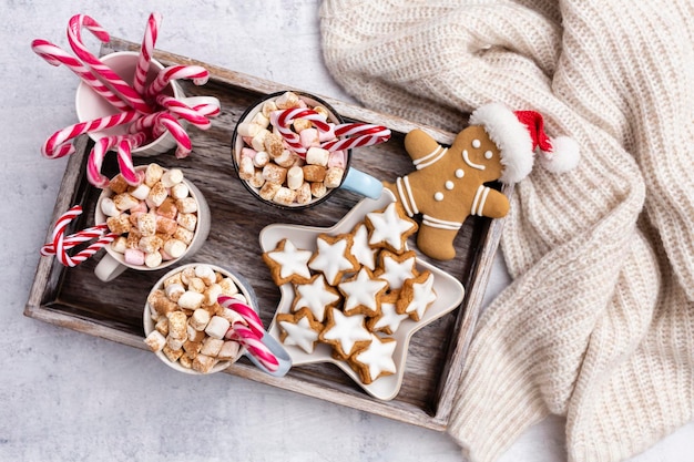 Pan de jengibre con taza de chocolate caliente y bastón de caramelo navideño.