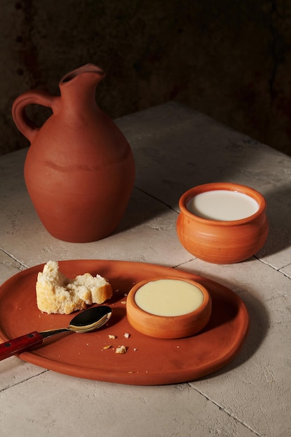 Foto pan de leche en cántaro de barro y leche condensada